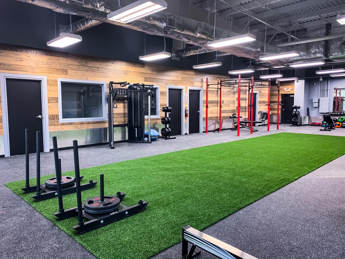 Training floor with turf lane and squat rigs at Core Progression North Austin